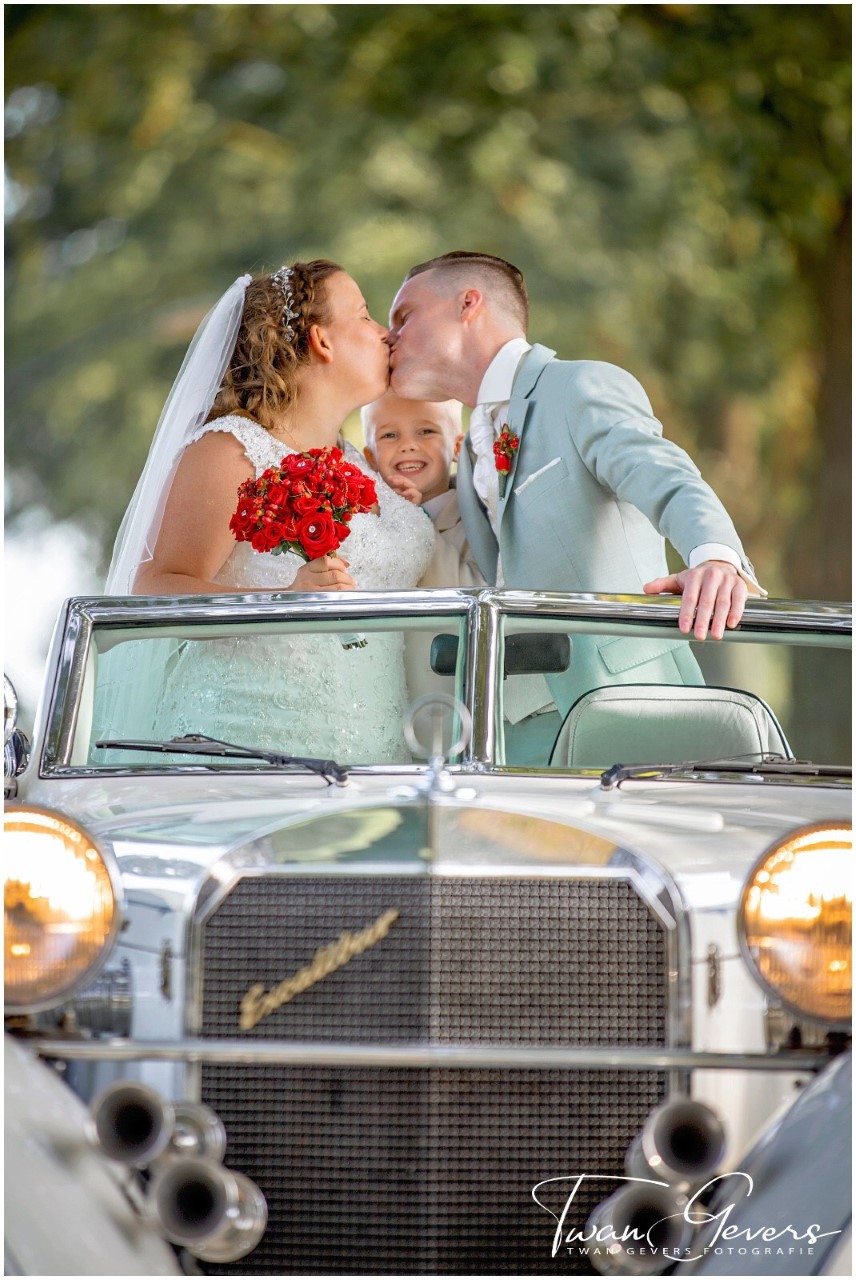 foto janet in auto met trouwjurk